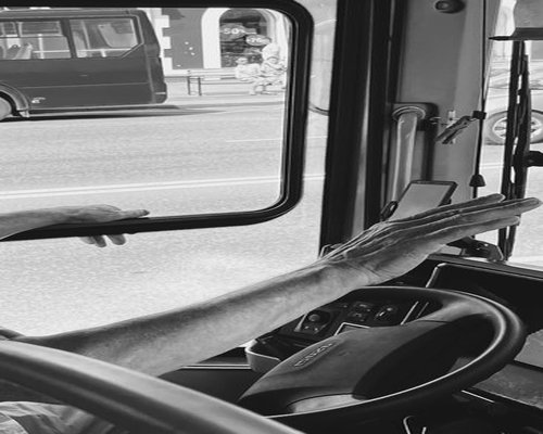 Person hands holding a black smartphone inside a moving public transport bus